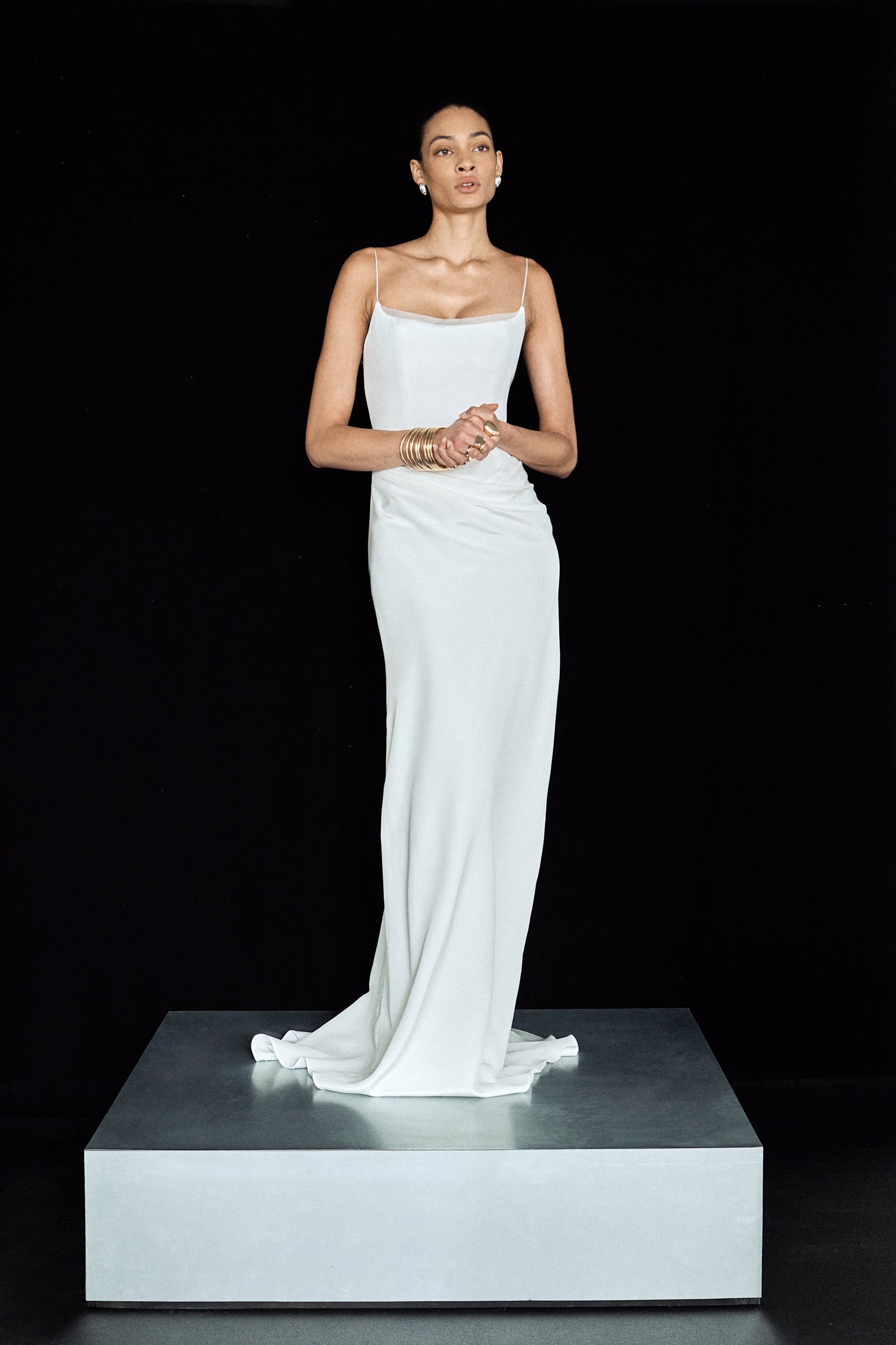 Front view of a woman in a corseted bridal gown with organza detailing at the neckline and slim straps
