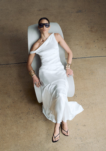 Woman wearing an asymmetric neckline wedding dress, styled with modern accessories