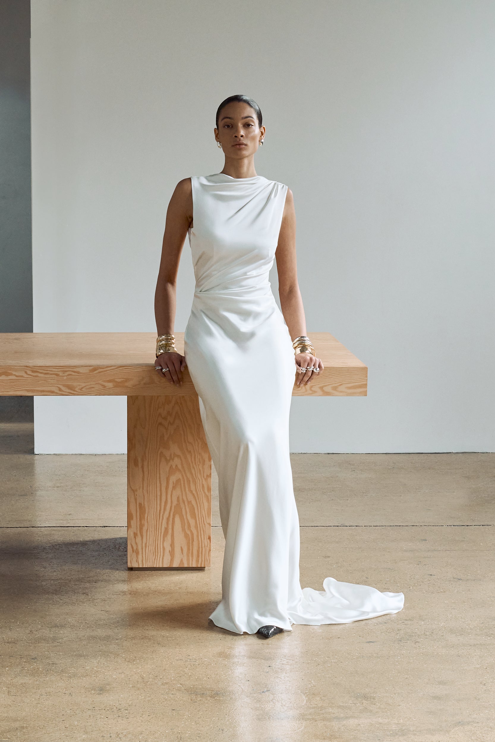 Front view of a silk wedding dress, featuring a high neckline and draped detailing