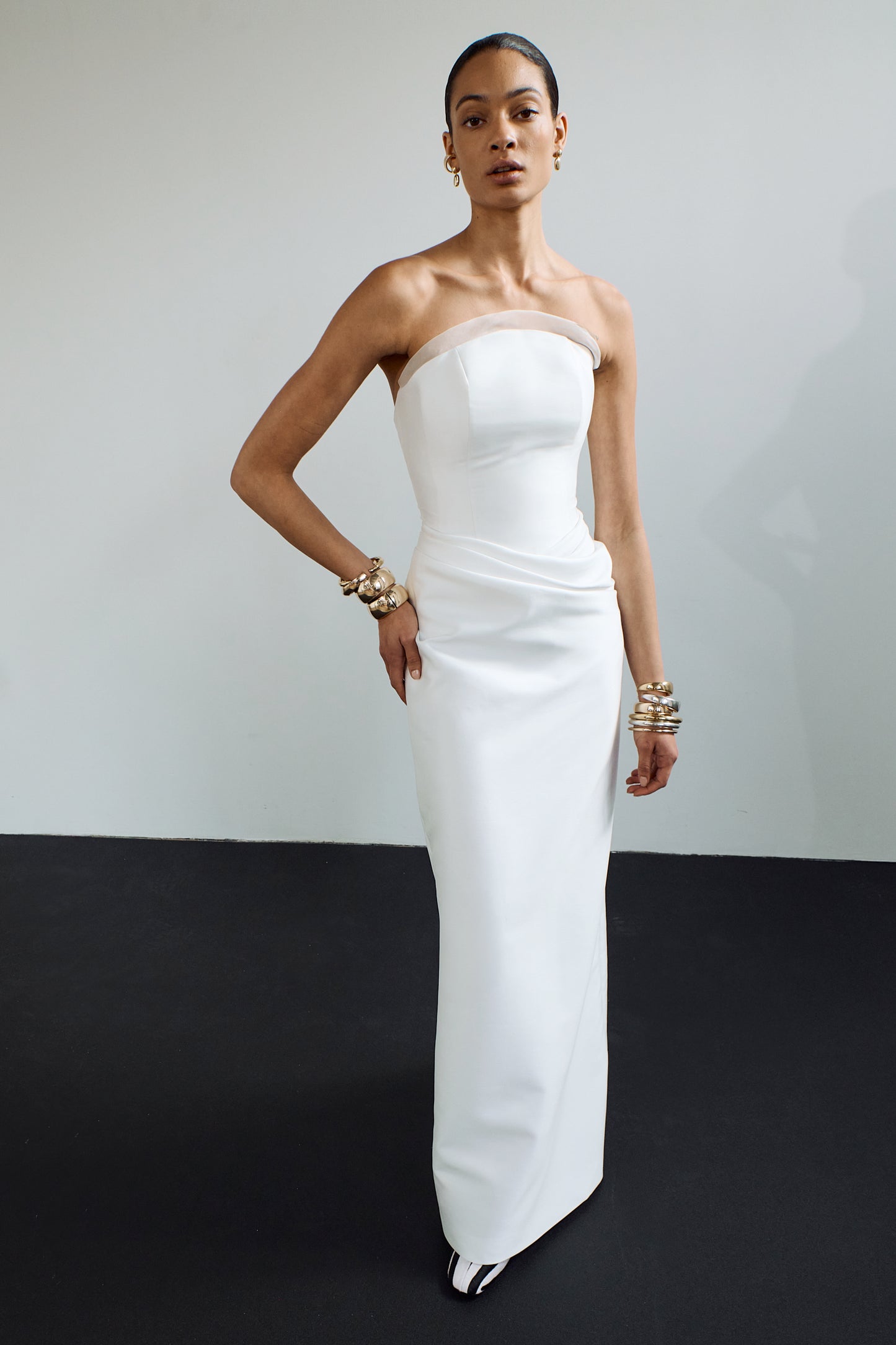 An elegant, minimalist column dress with a crescent neckline and organza trim