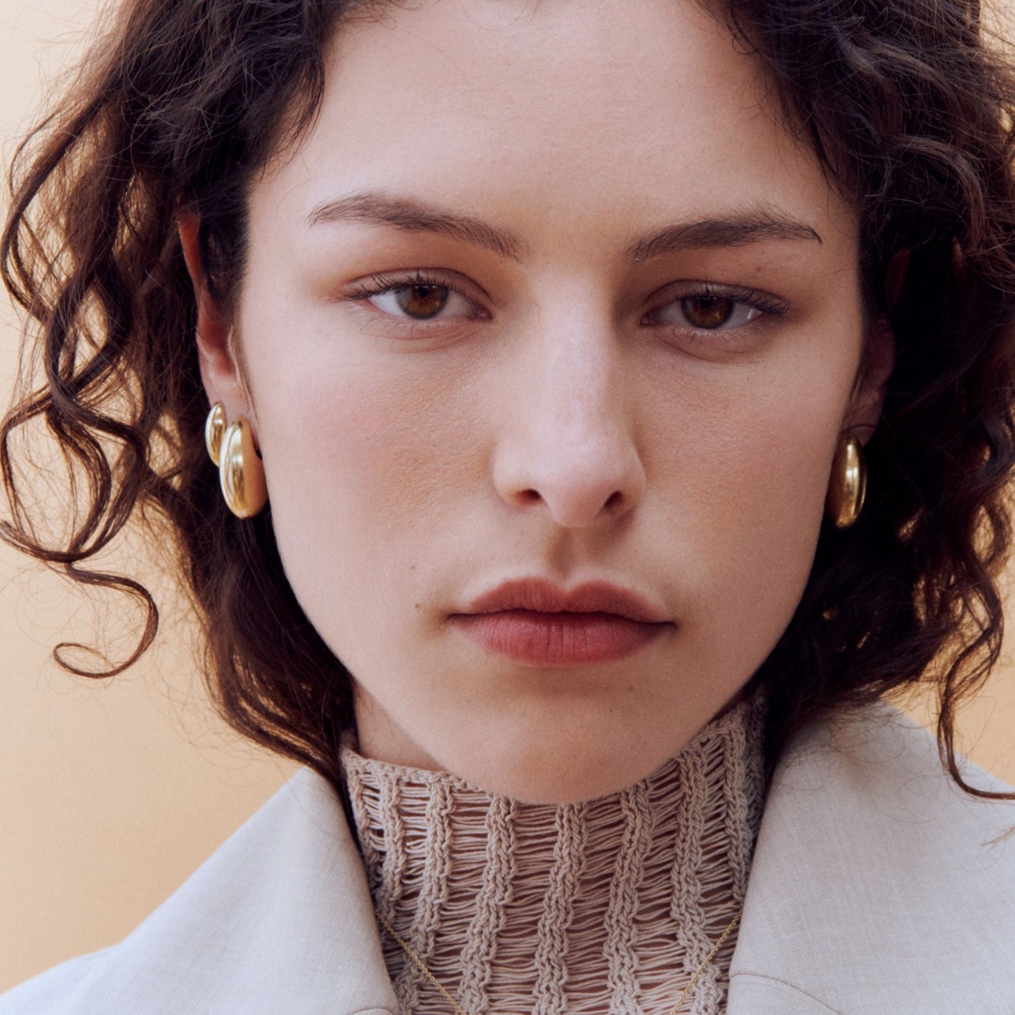 model wearing gold pebble earrings